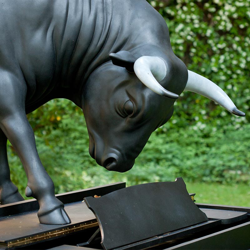 Life-size, black Spanish fighting bull in bronze, standing on concert grand piano staring down at the keyboard. 
