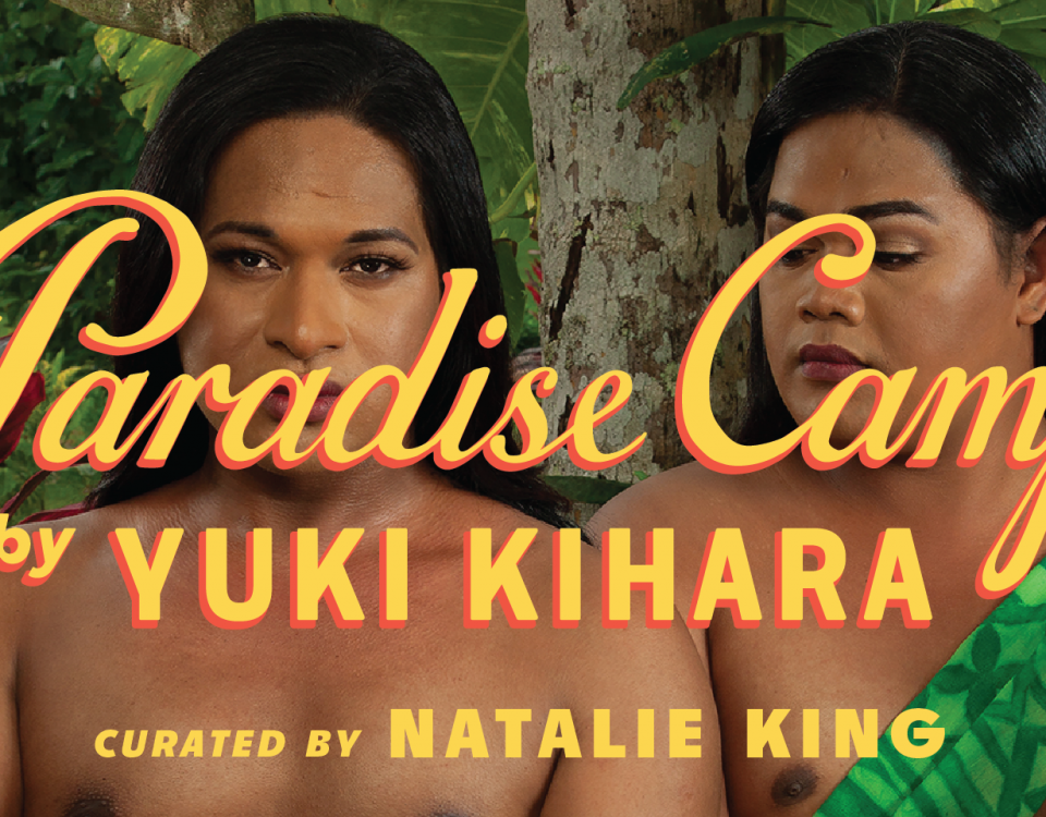 A photograph of two people standing in front of trees and plants. The person on the left is holding a plate of food. There is yellow text across the image reading Paradise Camp by Yuki Kihara, curated by Natalie King. There is a logo in the bottom left corner that is a yellow square reading New Zealand at Venice.